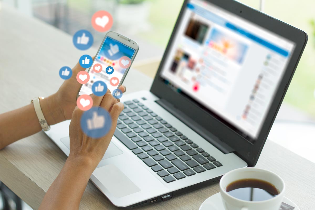 A woman using social media on her phone and laptop